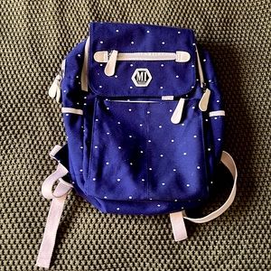 Dark blue polka dot travel backpack.